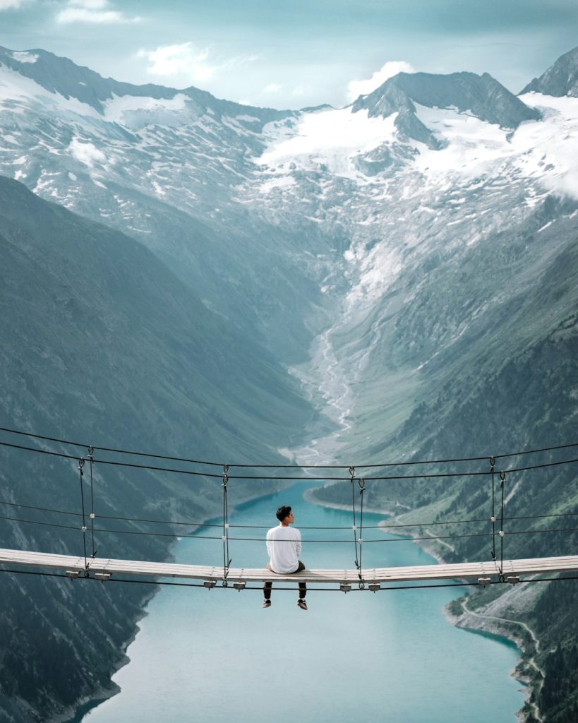 Über Man Wearing White Shirt Siting On Bridge Overlooking At Mountain Breigpd7xnq 819x1024